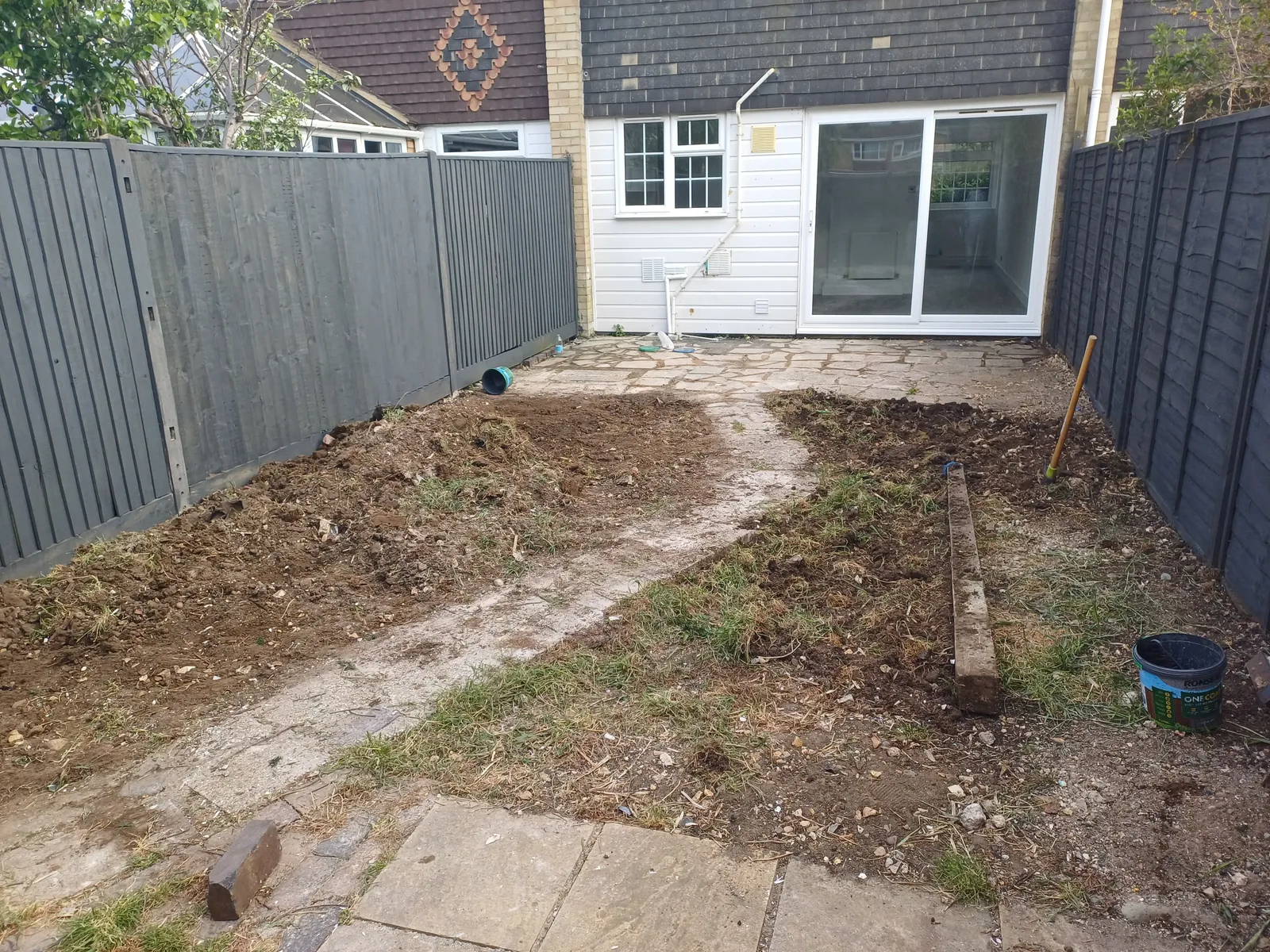 Before: bare, uneven ground prior to artificial grass installation